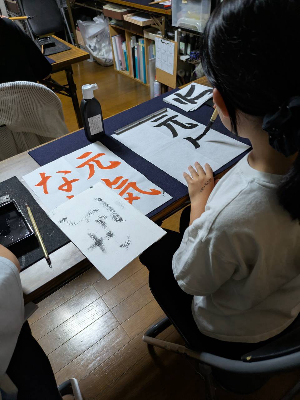 千詠書道 川越教室で朱色のお手本を見ながら「元気な声」を毛筆で書く生徒さん