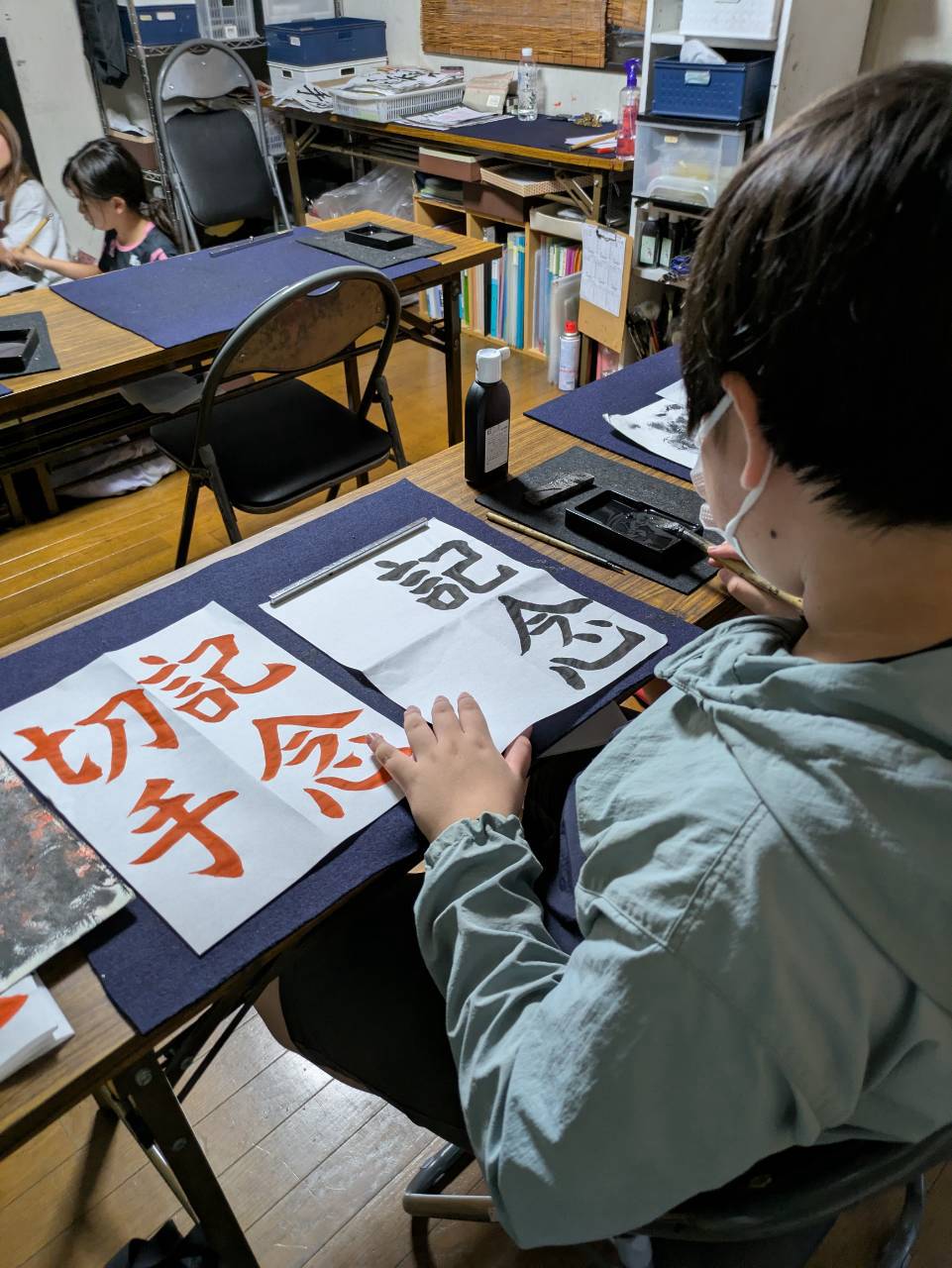 千詠書道 志木市教室で書き上げた「記念」をお手本と見比べる生徒さん
