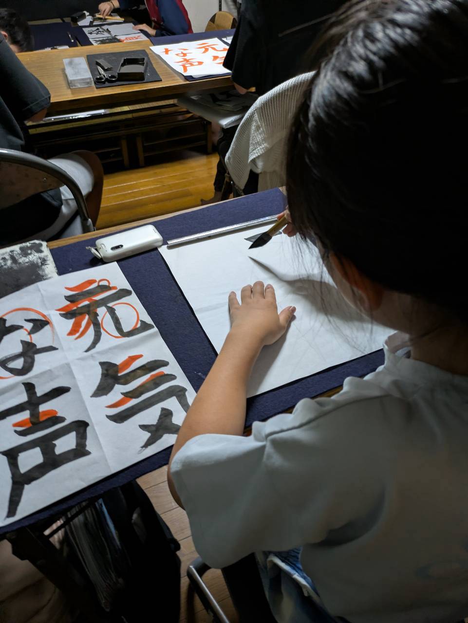 千詠書道 川越教室で先生の朱色の添削を確認しながら書き直す生徒さん
